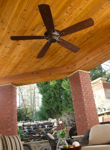 Photo of a ceiling fan in an outdoor patio with nature and a water fixture in the background